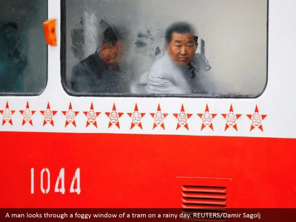 A man looks through a foggy window of a tram on a rainy day. REUTERS/Damir Sagolj