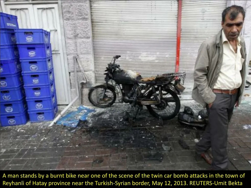 a man stands by a burnt bike near n.